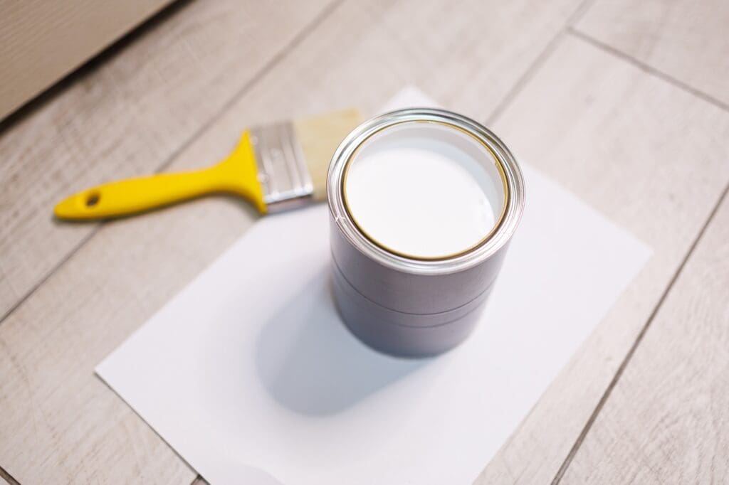 Can of white exterior paint, which should be stored somewhere warm before a cold-weather job