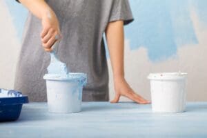 Woman mixing pigment and paint for wall painting