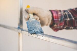 Professional painter preparing a metal railing for a residential painting project in Atkinson, NH - Painting Metal Surfaces